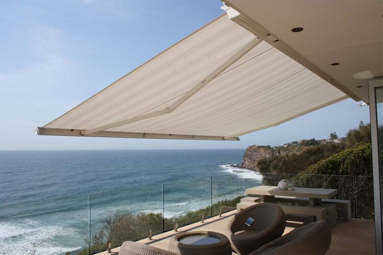 Retractable cassette awning adding shade for modern balcony with view of beach