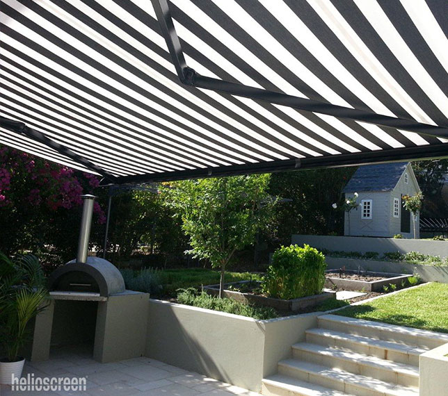 Black and white striped retractable awning adding shade for backyard
